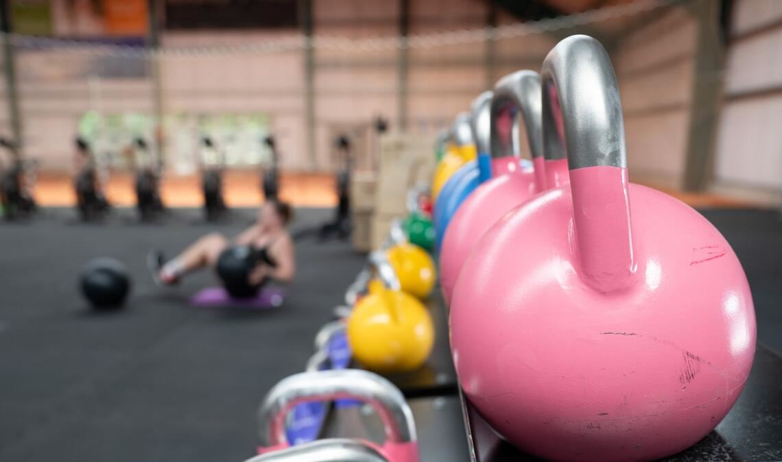 Eine Frau übt an einer Hantelbank.