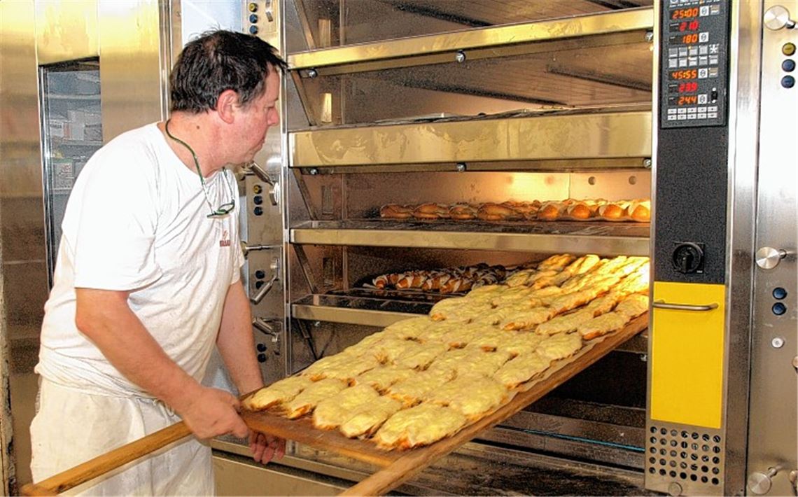 Eine Investition in die Technik sichert die Zukunft des Betriebs: Bäckermeister Ulrich Schmid prüft die Ware, die aus dem neuen Ofen kommt.
