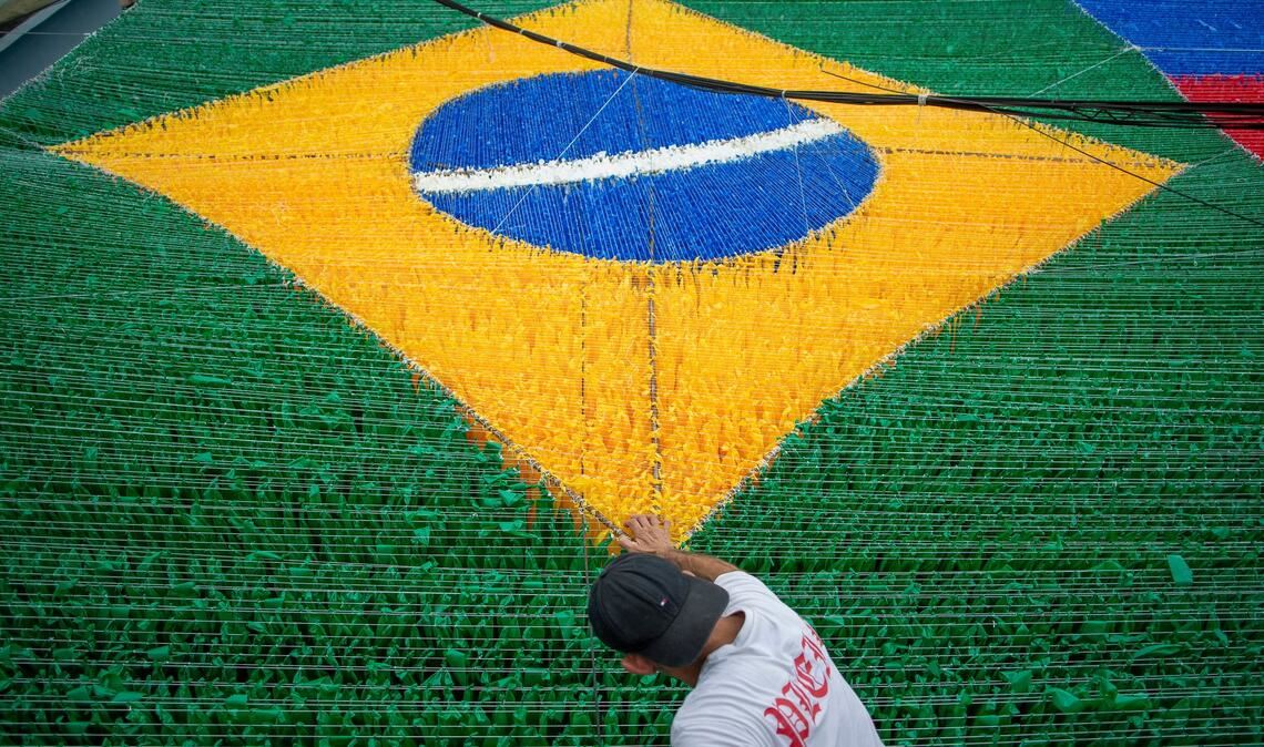 Eine Person gibt der hängenden Dekoration zur Feier der Fußballweltmeisterschaft 2026 auf der Rua 03 im Viertel Alvorada in Manaus, der Hauptstadt des brasilianischen Bundesstaates Amazonas, den letzten Schliff.