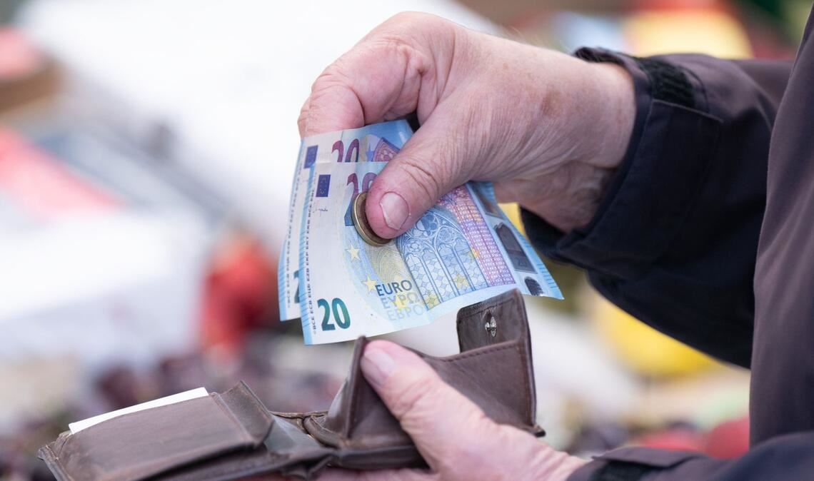 Eine Person sortiert auf einem Wochenmarkt das Wechselgeld für ihre Einkäufe in ein Portemonnaie.(Symbolfoto)