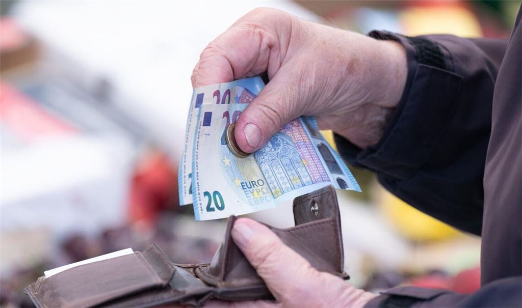 Eine Person sortiert auf einem Wochenmarkt das Wechselgeld für ihre Einkäufe in ein Portemonnaie.(Symbolfoto)
