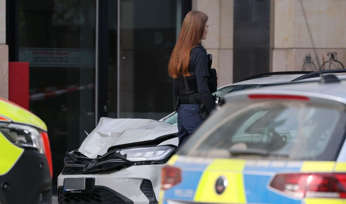Eine Polizistin steht an der Stelle, wo ein Auto in eine Menschengruppe gefahren ist.