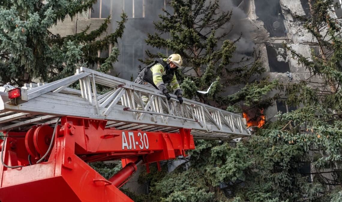 Eine Rettungskraft löscht einen Brand in einer medizinischen Einrichtung, die bei einem russischen Angriff auf Charkiw beschädigt wurde.