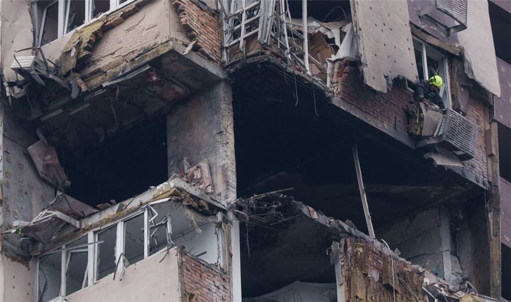 Eine Rettungskraft räumt die Trümmer eines mehrstöckigen Wohngebäudes weg, das bei einem russischen Drohnenangriff beschädigt wurde.