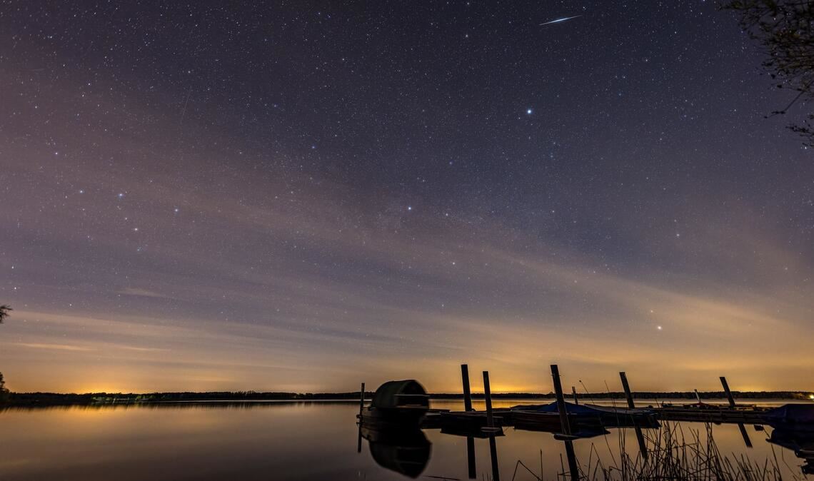 Eine Sternschnuppe der Lyriden ist am Nachthimmel über dem Spremberger Stausee in Brandenburg zu sehen.