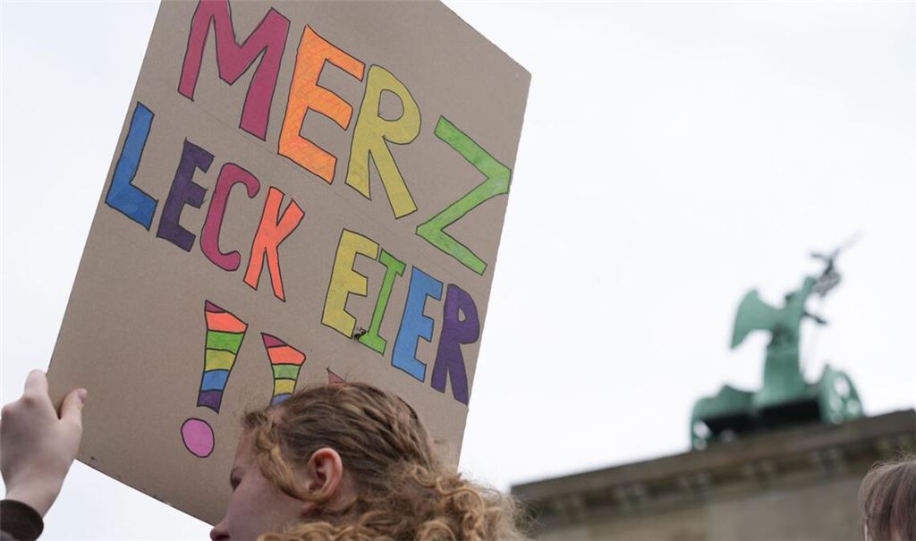 Eine Teilnehmerin einer Demonstration gegen die Wehrpflicht hält ein Plakat, auf dem steht „Merz leck Eier!!!“ (Archivfoto).
