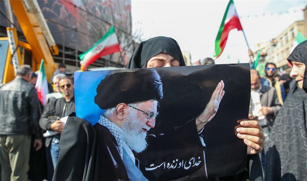 Eine Trauernde hält beim Begräbnis des von Israel getöteten Generalsekretärs des iranischen Sicherheitsrats, Ali Laridschani, ein Bild des ebenfalls getöteten Obersten Führers Ajatollah Ali Chamenei in die Höhe.