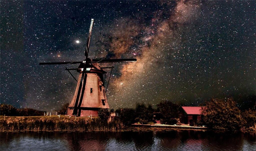 Eine Windmühle vor der Silhouette der Milchstraße.