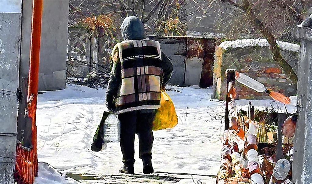 Eine alte Frau trägt im März 2025 ihre kargen Einkäufe aus einem Geschäft nahe des Bahnhofs von Pokrowsk in ihr zehn Kilometer entferntes Haus.