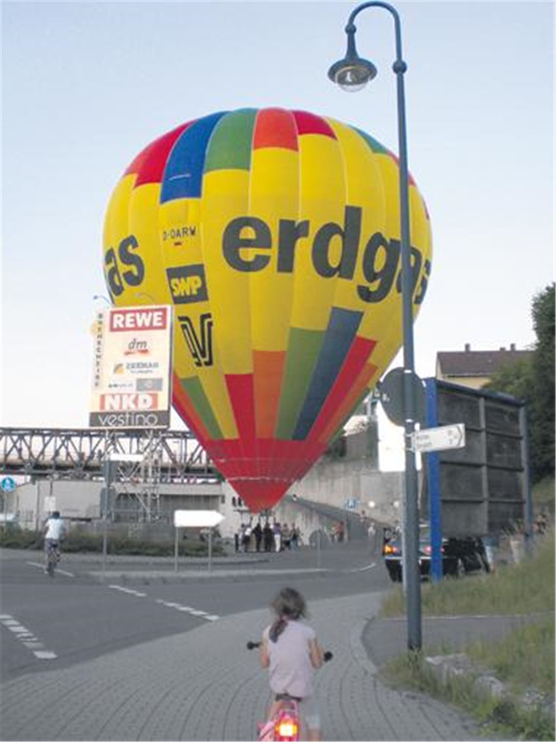 Eine außergewöhnliche Landung in Bildern (von oben): Erst steht der Ballon tief über der Stadt, dann landet er bei der Drehscheibe, und dann wird er mithilfe
von freiwilligen Helfern eingepackt.

Foto: Schröder