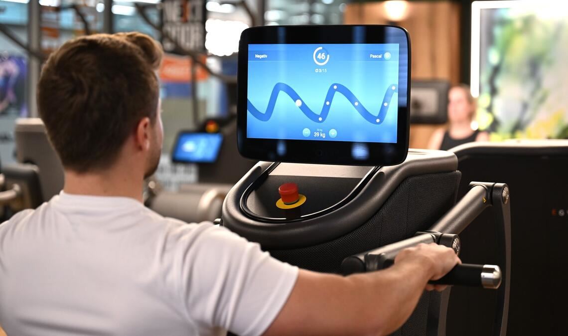 Eine digitalisierte Ruderbank in einem Fitnessstudio, auf deren Display der Nutzer mit seiner Kraftanstrengung eine Figur eines Computerspiel steuert: Solche Daten könnten für eine Trainingsanalyse ausgewertet werden.