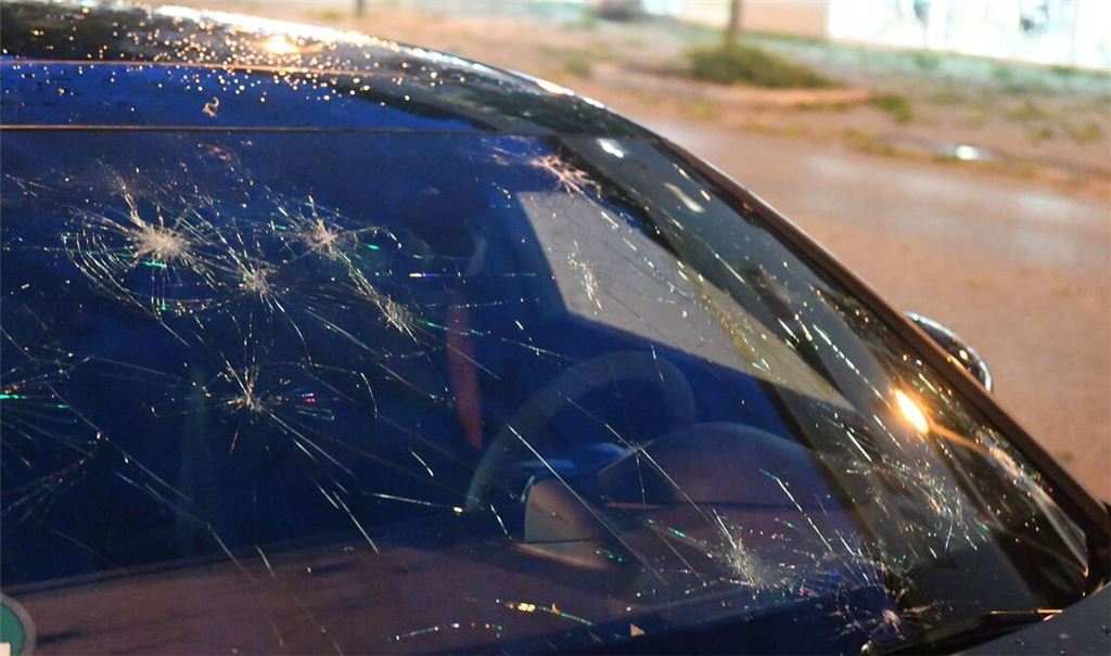 Eine durch Hagel bei einem Unwetter beschädigte Fensterscheibe eines Autos.