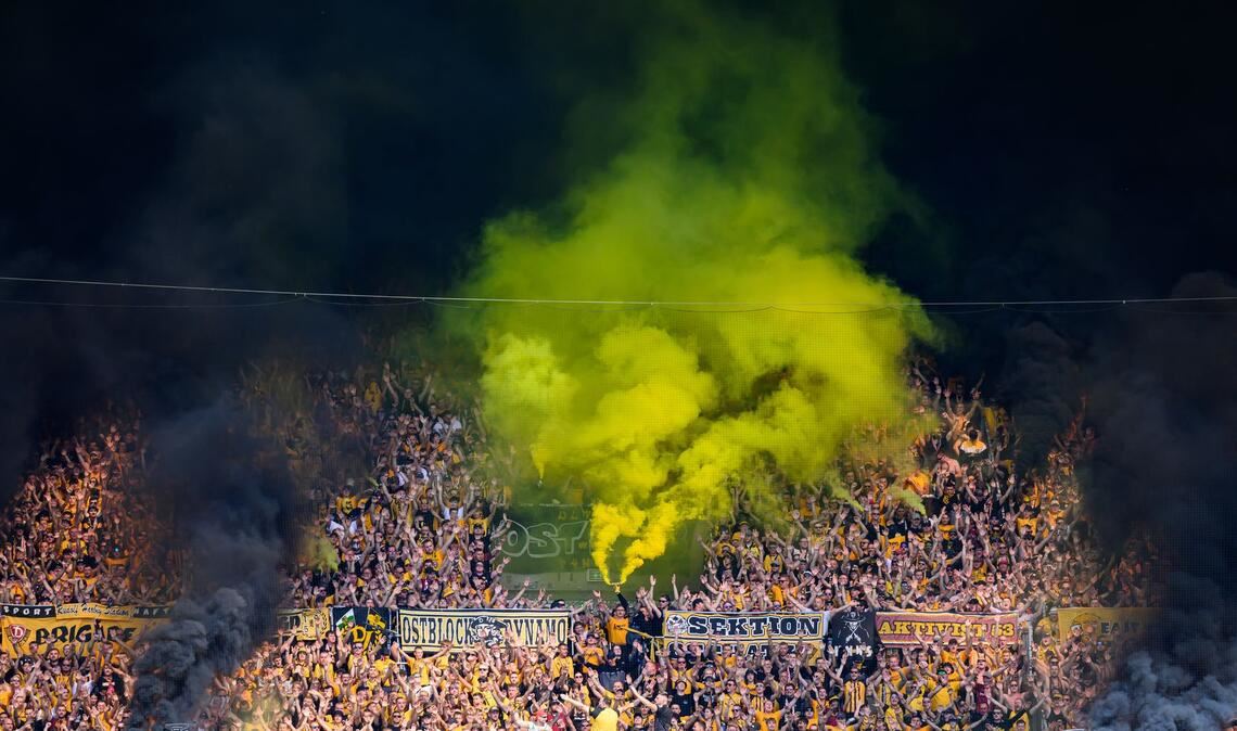 Eine grüngelbe Wolke steigt aus dem K-Block im Stadion.