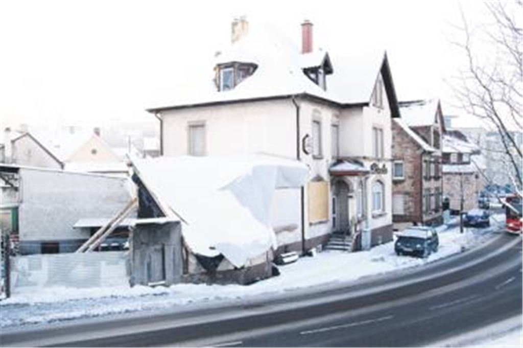 Eine schneebedeckte Plane verhüllt den verwüsteten Anbau der Linde. Doch darunter . . .