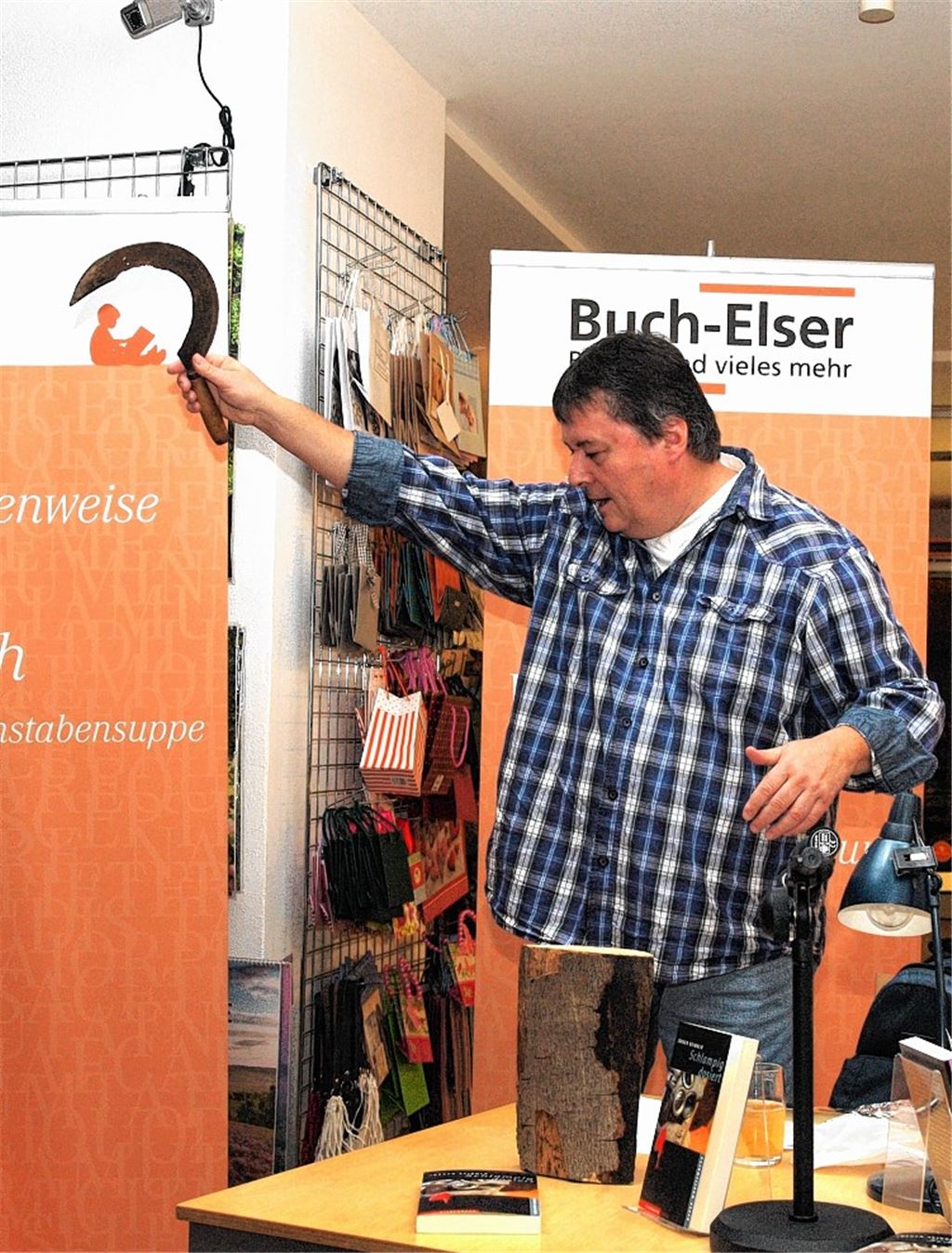 Eine von vielen Mordwaffen: Jürgen Seibold demonstriert im Rahmen der Lesung bei Buch-Elser eine Bluttat mit einer Sichel.