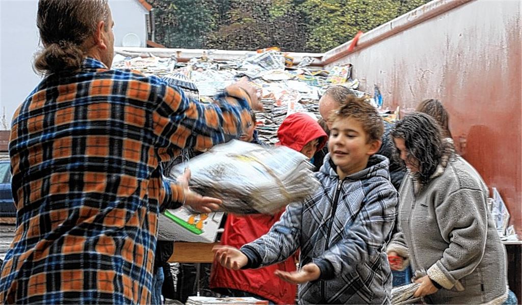 Einsatz im strömenden Regen: Eltern und Schüler füllen den Altpapier-Container.