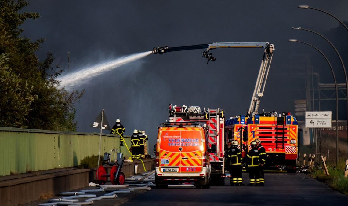 Einsatzkräfte der Feuerwehr versuchen, einen Brand in einem Industriegebiet im Hamburger Hafen zu löschen.