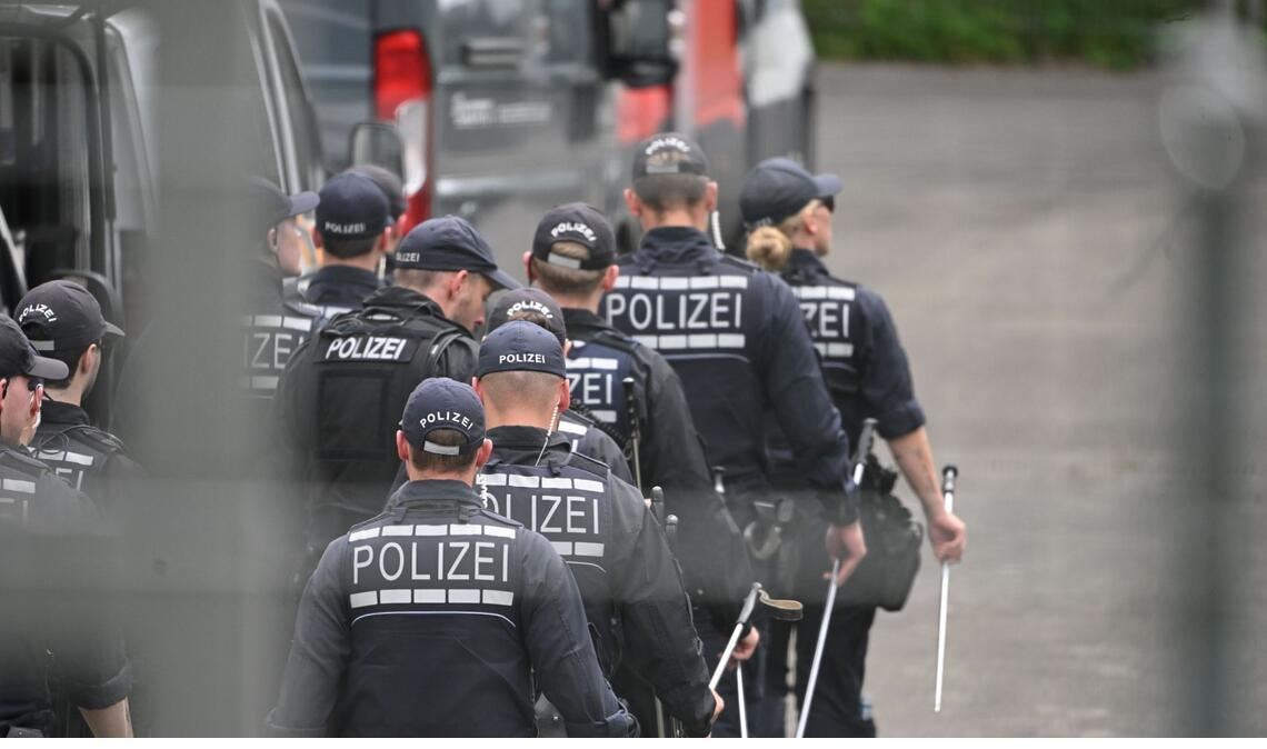 Einsatzkräfte der Polizei gehen im Rahmen der Ermittlungen auf dem Gelände eines Umspannwerks, in dem es in der Nacht gebrannt hatte.