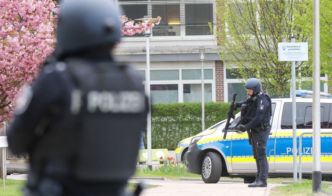 Einsatzkräfte der Polizei suchen am Krankenhaus in Pinneberg nach einer flüchtigen Person.