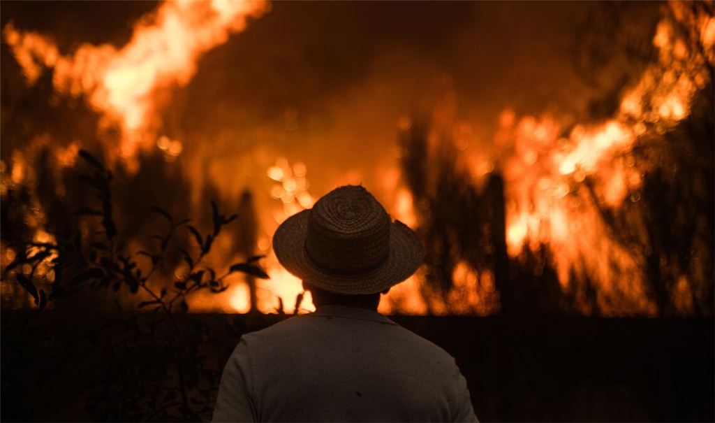 Einwohner von Cualedro in der Provinz Ourense, Galicien, Spanien, beobachten die Ausbreitung des Feuers.