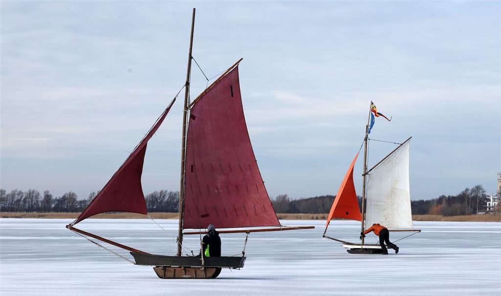 Eissegler sind auf dem zugefrorenen Bodden bei Wustrow auf der Halbinsel Fischland unterwegs.