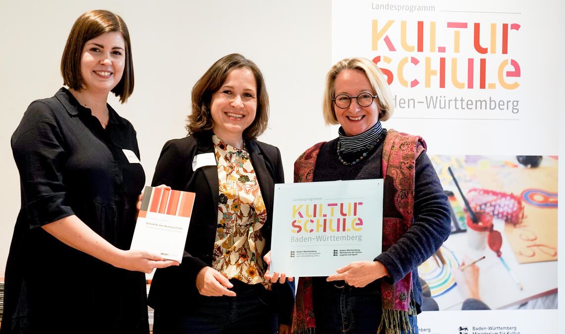 Elisa Adams, KIT Karlsruhe und Dr. Katja Brandenburger vom Kultusministerium (v. li.) überreichen Studiendirektorin Henriette Dieterle das Kulturschule-Siegel. Foto: © Daniela Wolf