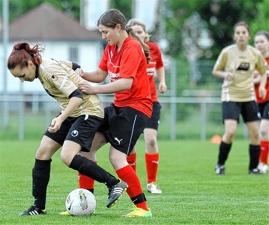 Energisch luchst Knittlingen (rote Trikots) den Enzberger Frauen den Ball ab. Foto: Fotomoment