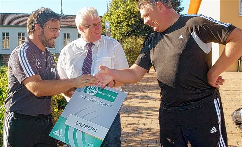 Enzberg ist nun DFB-Stützpunkt. Thilo Dettinger (Mitte) und Heinz Voges (re.) nehmen für den FC Viktoria von Damir Dugandzic die entsprechende Urkunde entgegen. Fotos: Fotomoment