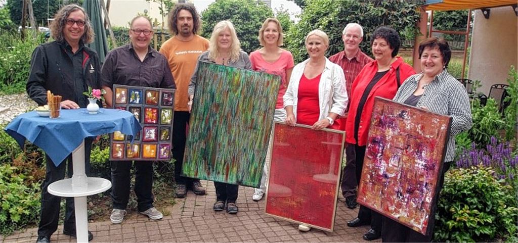 Erika Kruschina, Gabriele Higer, Mirjana Simunovic und Martina Wolf (vorne v. re.) haben Bilder des Künstlers Harry Klenk (2. v. li.) ersteigert. Den Erlös aus der Auktion übergeben Klenk und Bertram Haak (li.), Geschäftsführer der Genossenschaft Rosswag-Mühlhausen, an Lebenshilfe-Heimleiter Norbert Winter, Sandra Sailer und Stefan Baiker (hinten v. re.). Foto: Fotomoment