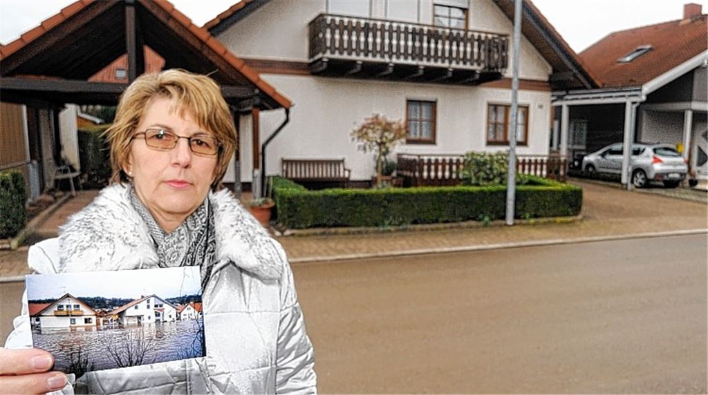 Erinnerungen: Marga Vogel mit einem Foto, das am Morgen des 21. Dezember 1993 entstanden ist. Das erst ein Jahr zuvor bezogene Haus steht mitten in einem reißenden Fluss.