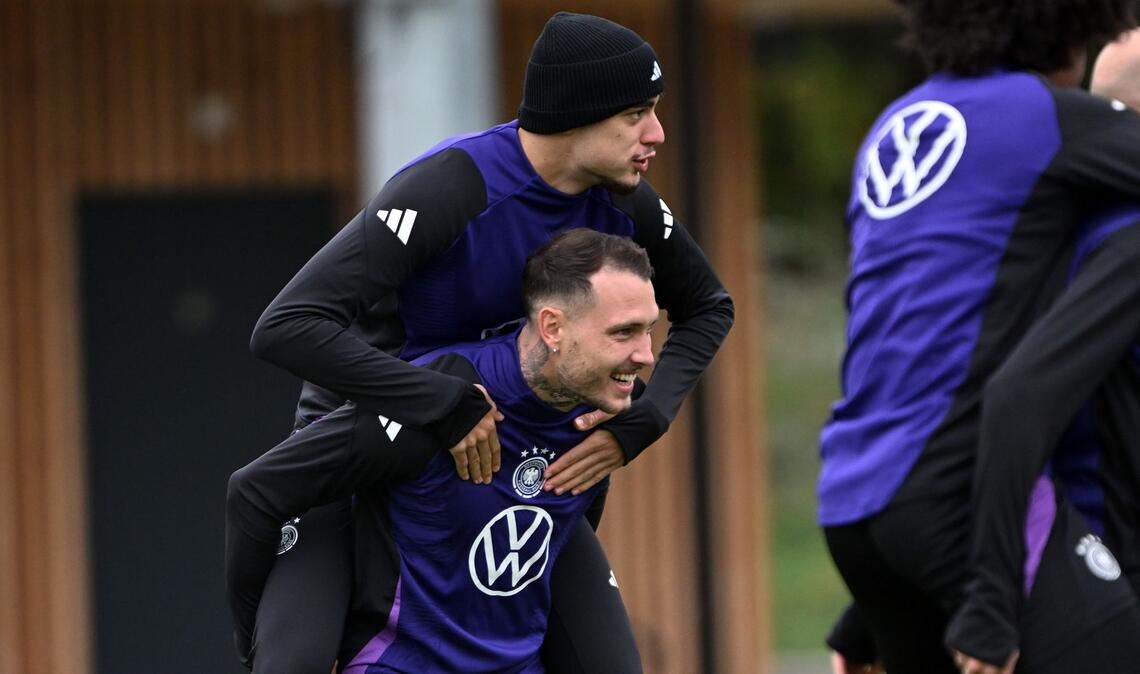 Erst Huckepack dann Doppelpack? Beim Training der Fußball-Nationalmannschaft vor dem WM-Quali-Spiel gegen Luxemburg trägt David Raum Aleksandar Pavlovic auf den Schultern.