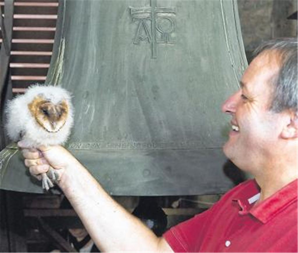 Eulen-Nachwuchs in der Andreas-Gemeinde: Pfarrer Beatus Widmann im Glockenturm mit einem der Nesthäkchen. Foto: Wilhelm
