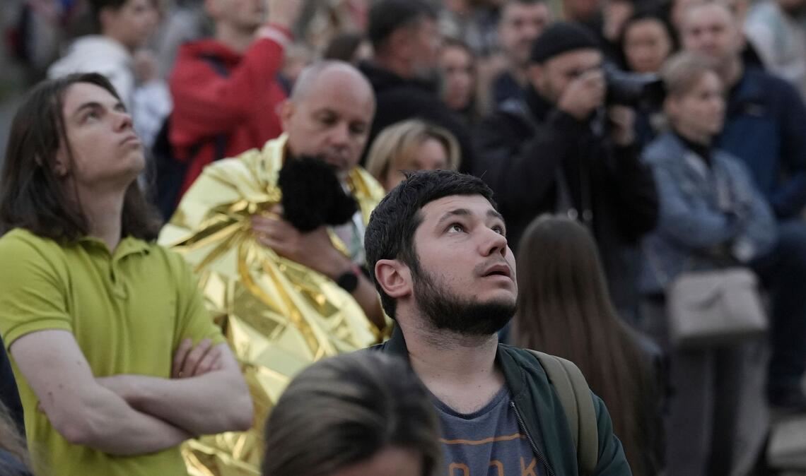 Evakuierte Bewohner sehen sich ihr mehrstöckiges Wohnhaus an, das während des Angriffs auf Kiew beschädigt wurde.