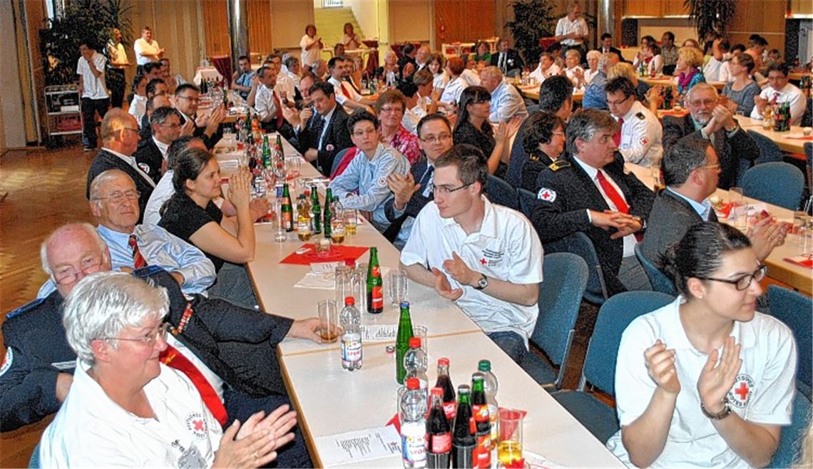 Fast 200 geladene Gäste feiern das 100-jährige Bestehen des DRK-Ortsvereins Mühlacker. OB Frank Schneider (Bild oben re.) gratuliert stellvertretend dem Vorsitzenden Thomas Krack mit einem Scheck über 200 Euro zum Jubiläum. Die Kinder und Jugendlichen vom Jugendrotkreuz (Bild unten re.) reisen in ihrem Theaterstück mit der Zeitmaschine in die Zukunft. Fotos: Stahlfeld