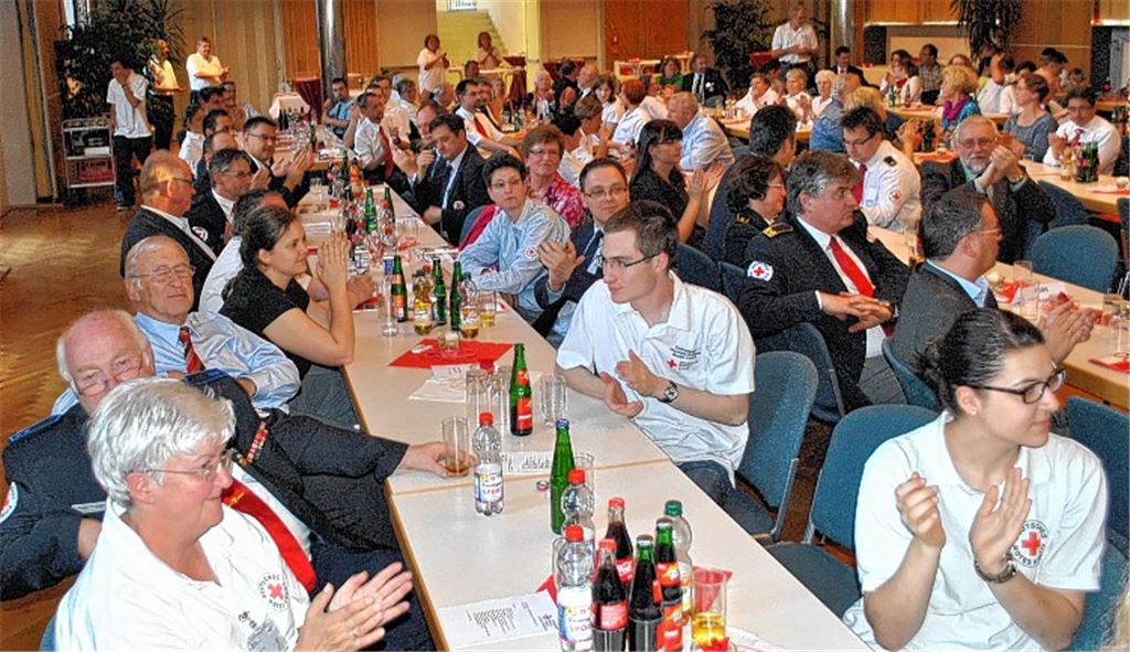 Fast 200 geladene Gäste feiern das 100-jährige Bestehen des DRK-Ortsvereins Mühlacker. OB Frank Schneider (Bild oben re.) gratuliert stellvertretend dem Vorsitzenden Thomas Krack mit einem Scheck über 200 Euro zum Jubiläum. Die Kinder und Jugendlichen vom Jugendrotkreuz (Bild unten re.) reisen in ihrem Theaterstück mit der Zeitmaschine in die Zukunft. Fotos: Stahlfeld