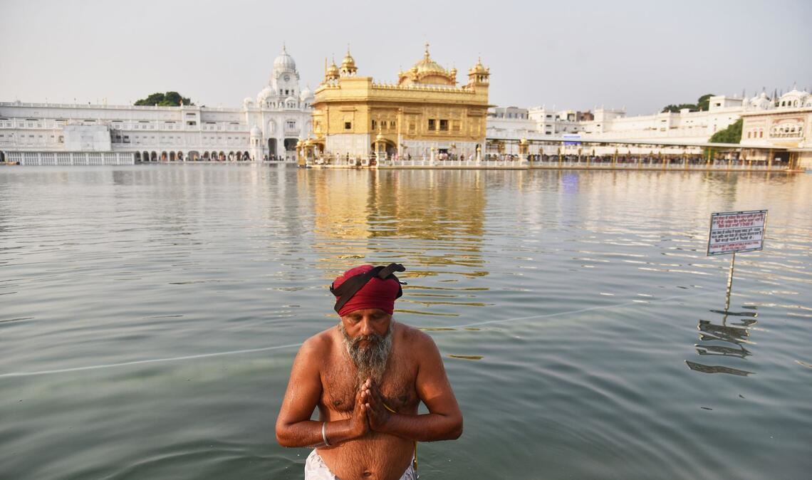 Feiertag Guru Nanak Jayanti: Sikh-Anhänger nimmt ein heiliges Bad im Goldenen Tempel.