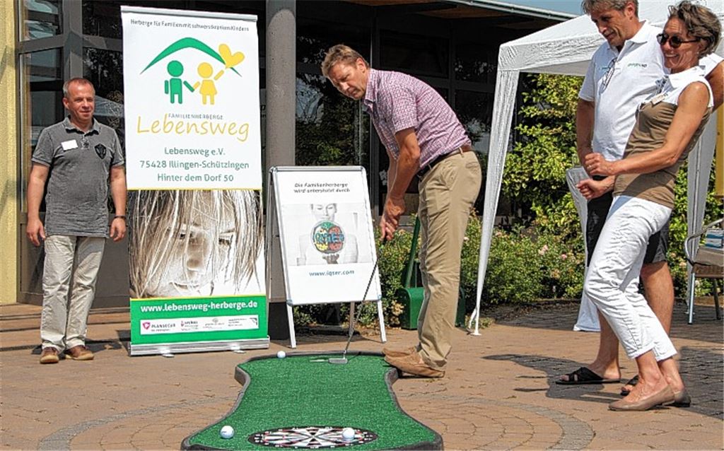 Feingefühl statt Vollspann: Guido Buchwald versucht das Putten. Andreas Heimberg (li.) und Susanne Kiefner vom Lebensweg-Verein sowie Heinz Briem von Golfyouup sehen zu.