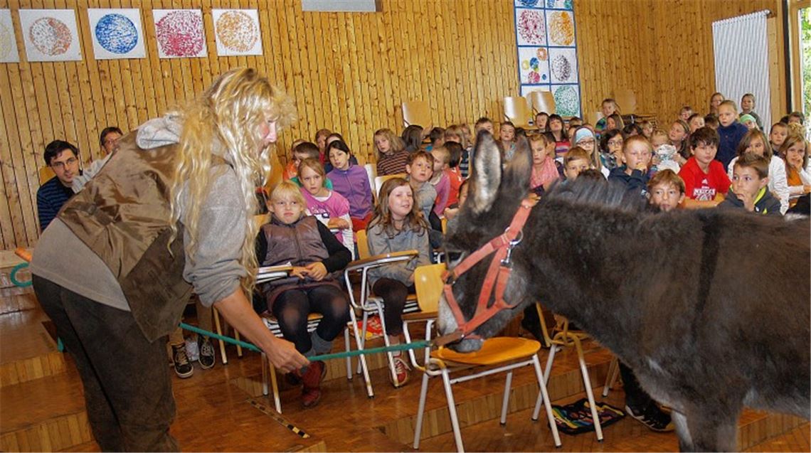 Felicia Ruhland zeigt den Schülern Eselin Rosalie, die sich über das gespendete Futter freut.