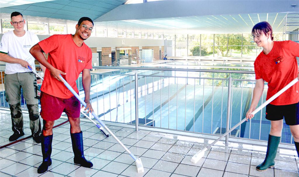Ferienhelfer Luca Norberg (v.li.) und die Azubis Modou Gueye und Zoe Merkle machen das Hallenbad fit für die neue Saison.  Fotos: Stahlfeld