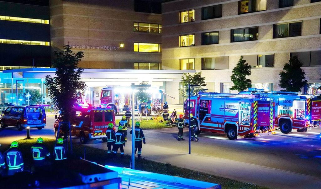 Feuerwehrfahrzeuge und Einsatzkräfte stehen vor dem Klinikum in Mödling.