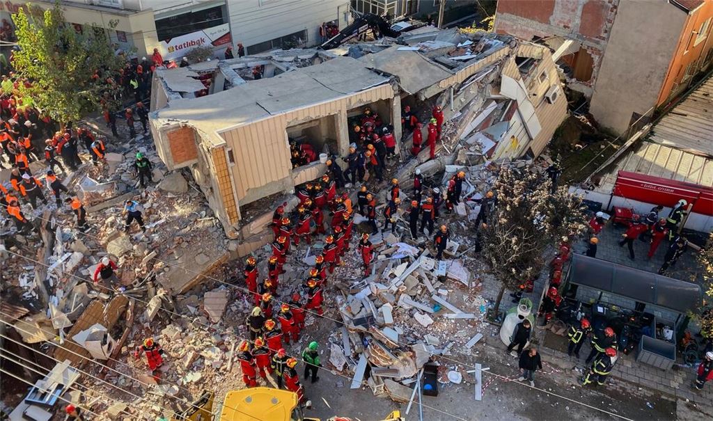 Feuerwehrleute und Rettungskräfte suchen nach dem Einsturz eines Wohngebäudes nach Verschütteten.