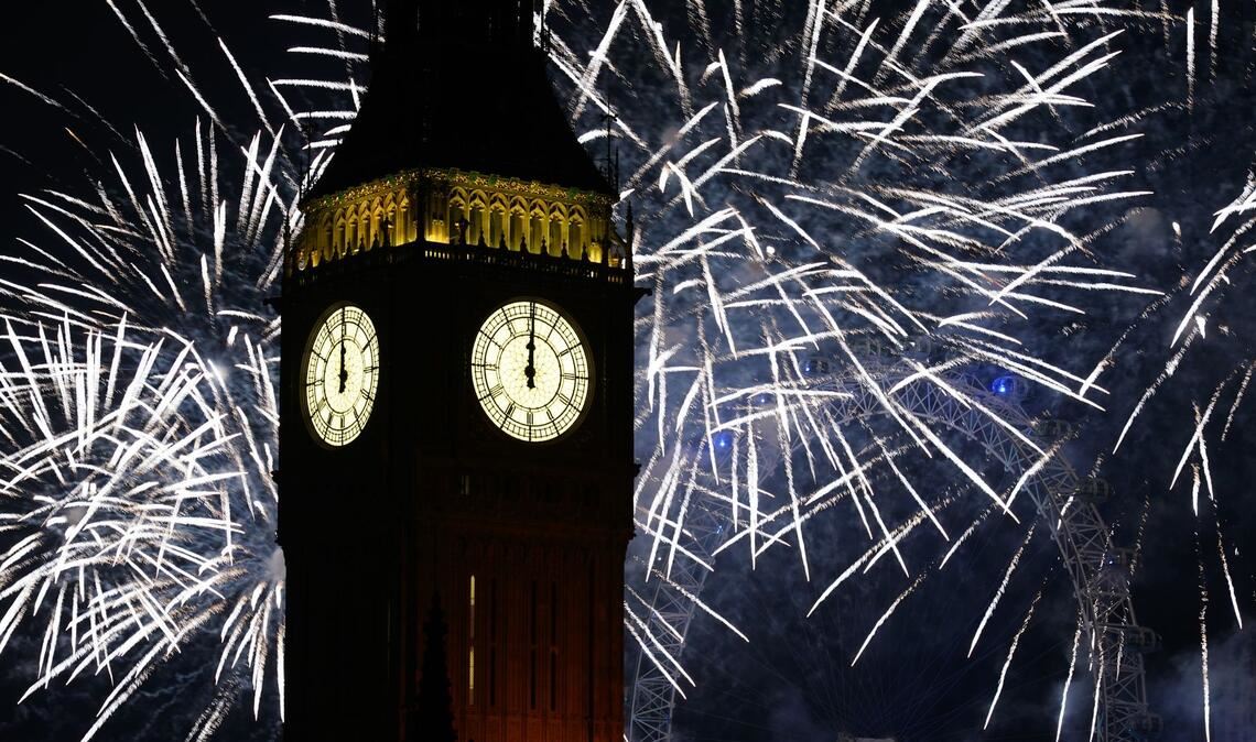 Feuerwerk erhellt den Himmel über dem Elizabeth Tower und dem London Eye im Zentrum Londons während der Neujahrsfeierlichkeiten.