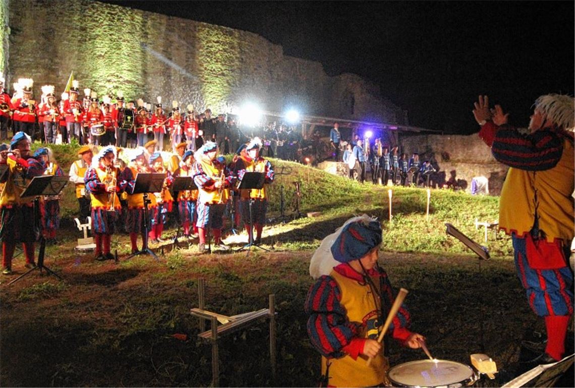 Finale des Eröffnungskonzerts im Burginnern mit den gastgebenden Trommlern und Pfeifern (links im Vordergrund) und Stabführer Ralf Lauer (rechts).