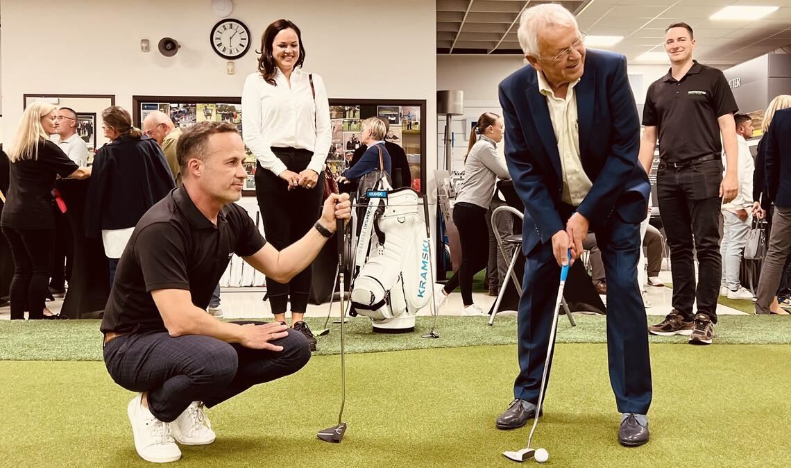 Firmengründer Wiestaw Kramski (re.) zeigt, wie das Putten auf dem 200 Quadratmeter großen Indoor-Green, dem Herzstück des Indoor Golf Center in Birkenfeld, funktioniert.