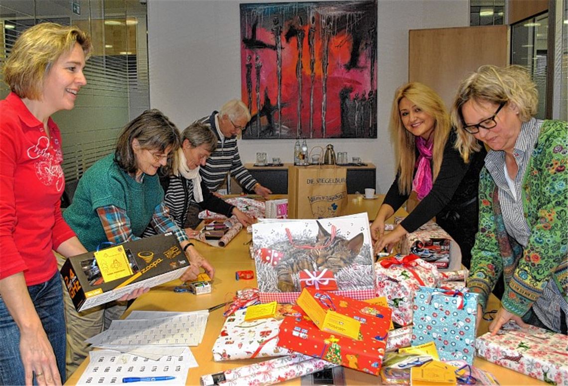 Fleißige Helferinnen verpacken bei der Volksbank in Mühlacker Geschenke der Wunschbaum-Aktion. Foto: Stahlfeld