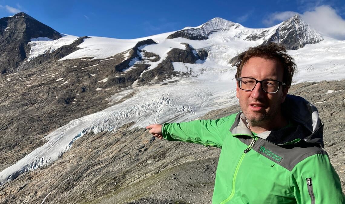 Florian Jurgeit vom Nationalpark Hohe Tauern zeigt von der Neuen Prager Hütte auf den inzwischen weit entfernten Gletscher.