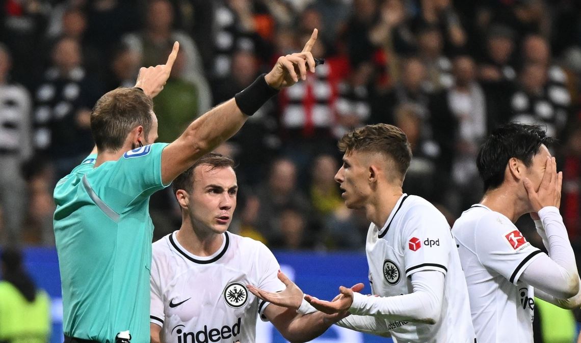 Frankfurts Daichi Kamada (r-l), Jesper Lindström und Mario Götze beschweren sich bei Schiedsrichter Sascha Stegemann.