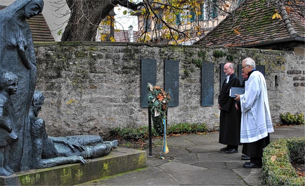 Franz Hebeda, Johann Sturm und Pfarrer Wolfgang Schlecht (v. re.) vor dem Illinger Ehrenmal.