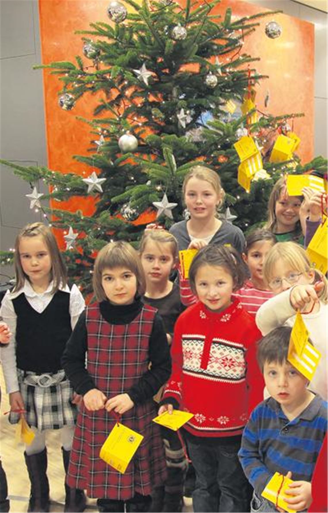 Frohe Weihnachten für alle Kinder: Bei der Auftaktveranstaltung hängen die jungen Sänger aus dem Chor der Paulus- und Andreasgemeinde die mehr als 130 Wunschzettel aus dem Tafelladen an den Weihnachts-Wunschbaum in der Volksbank. Archivfoto: Disselhoff
