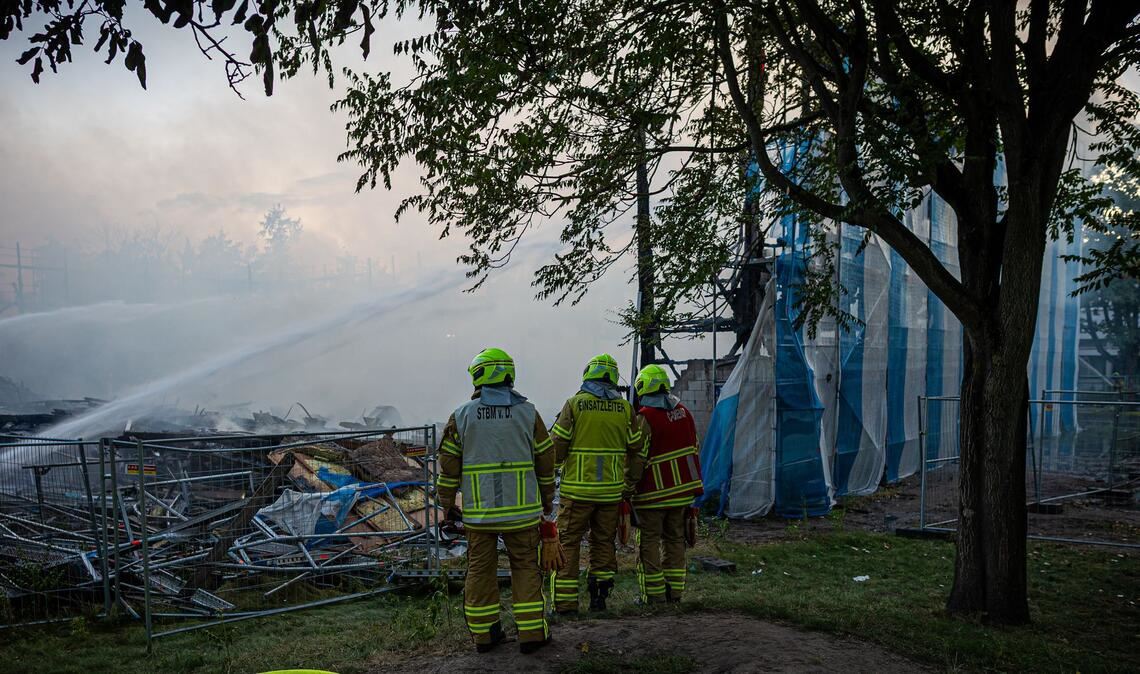 Führungskräfte der Feuerwehr besprechen sich bei dem Brand einer Sporthalle in Hannover.